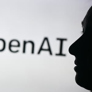 An image of a woman holding a cell phone in front of the Open AI logo displayed on a computer screen, on April 29, 2024, in Edmonton, Canada.