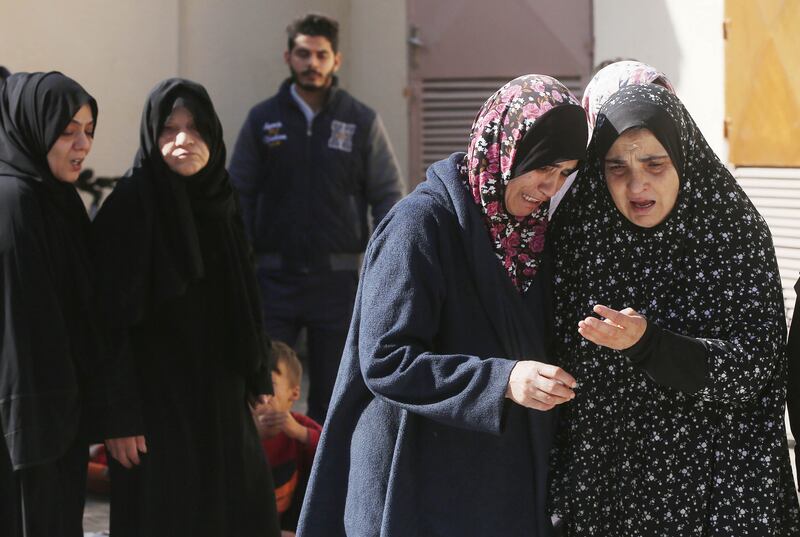 Two women hold each other and cry in Gaza