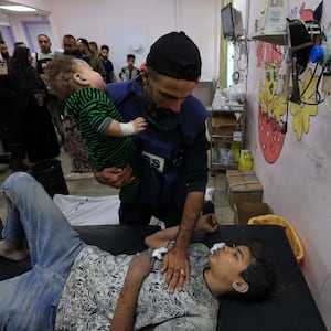 A man holds an injured child at the Al-Quds Hospital in Gaza.