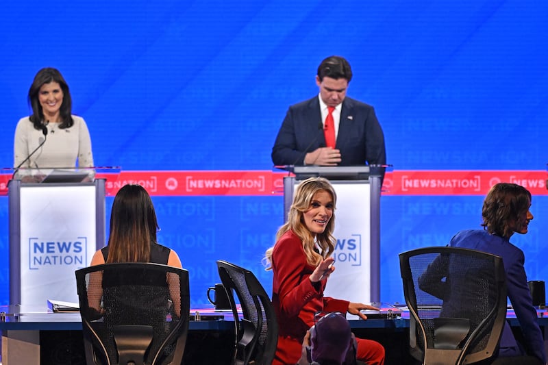 Moderator Megyn Kelly gestures in the foreground as former UN ambassador Nikki Haley Florida Gov. Ron DeSantis arrive onstage ahead of the fourth Republican presidential primary debate at the University of Alabama on December 6, 2023.