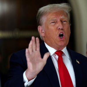 Former U.S. President Donald Trump gestures while talking to the media during a break as he attends trial in a civil fraud case