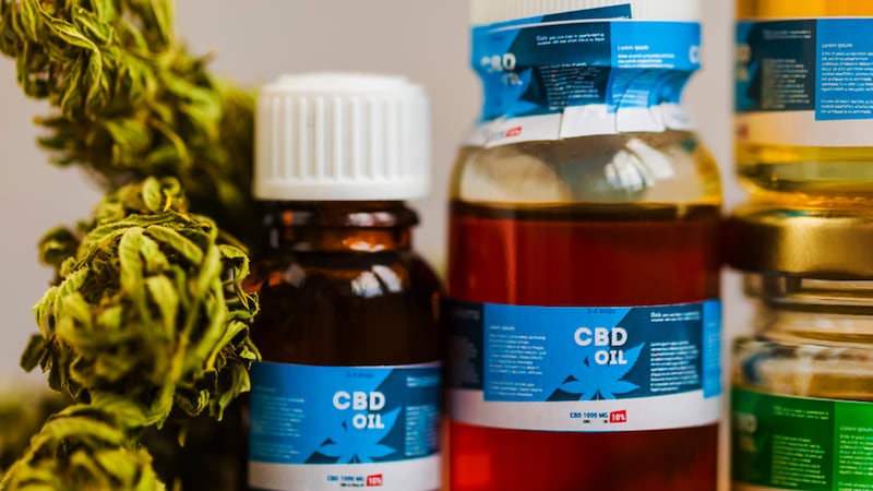 bottles of cbd oil from marijana framed by leaves