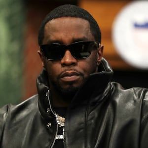 Sean Combs stares forward, wearing a leather jacket and glasses.