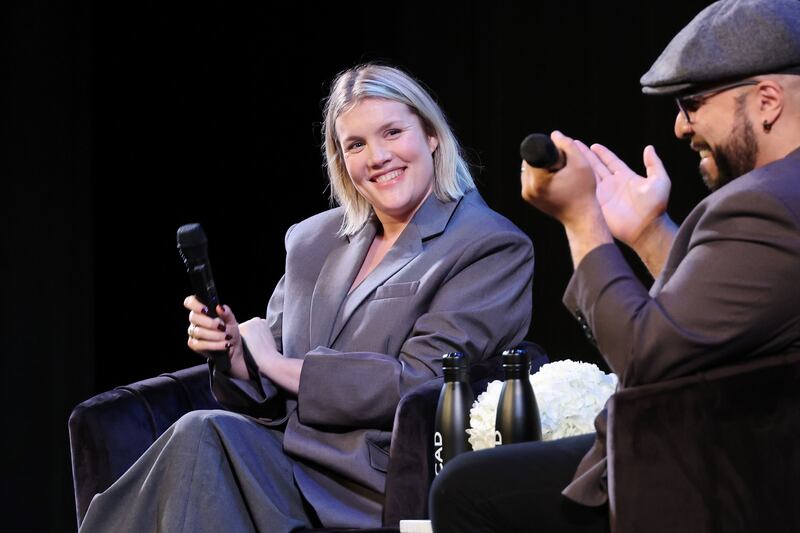 Emerald Fennell holds a microphone during a Q&A with Clayton Davis at a screening of her film ‘Saltburn.’