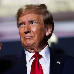 Former President Donald Trump reacts at a campaign event ahead of the Republican presidential primary election