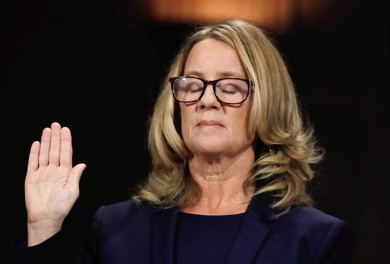 Christine Blasey Ford raising her hand, her eyes are closed