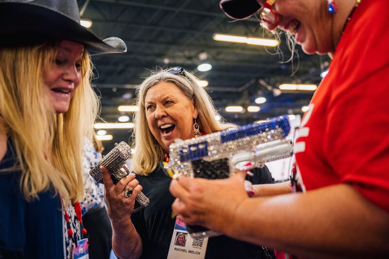 Women express excitement over handgun merchandise during the Conservative Political Action Conference in Dallas.