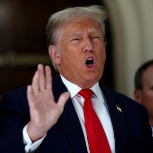 Donald Trump gestures while talking to the media during a break as he attends trial in a civil fraud case