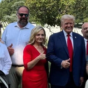 Donald Trump was photographed smiling and giving an awkward thumbs up Monday at the graves of fallen Marines in Arlington National Cemetery.