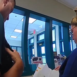 A Moms for Liberty member shows cops a book.