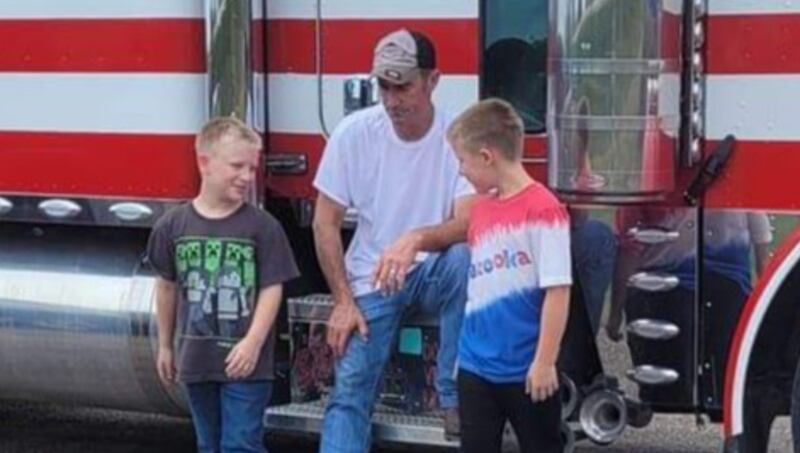 David Schultz sits on his rig along with his twin sons.