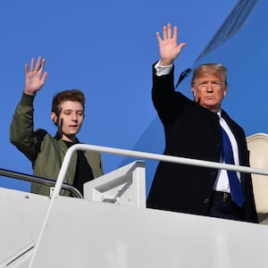 US President Donald Trump and son Barron Trump wave while making their way to board Air Force One at Andrews Airforce Base, Maryland on January 17, 2020. 