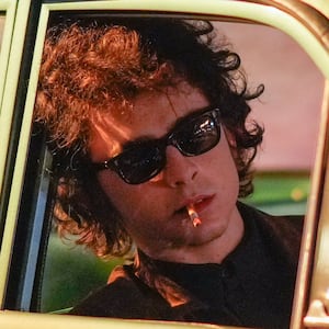 Timothee Chalamet is seen on location leaning out of a car window smoking a cigarette for the Bob Dylan biopic titled 'A Complete Unknown'