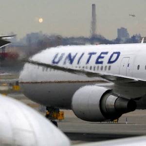 United Airlines planes taxi on a busy runway.