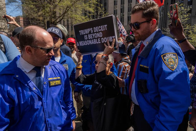 Officers escort an anti-Trump protester away from pro-Trump demonstrators.