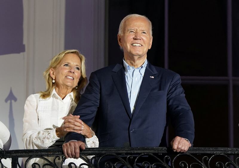 Joe and Jill Biden on White House balcony. Jill is clinging to Joe