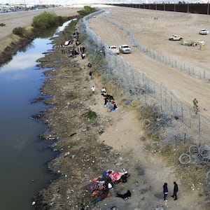 Migrants try to persuade the agents of the Texas National Guard to open the fence in Ciudad Juarez, Mexico on March 19, 2024.