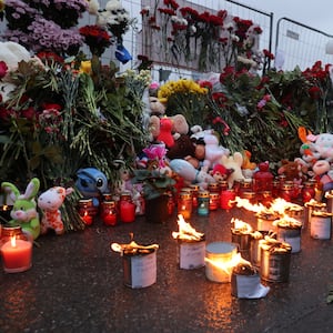 People light candles in honor to the victims of the Crocus City Hall terrorist attack near the Crocus City Expo Complex on March 23, 2024 in Krasnororsk, Russia.