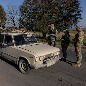 Ukrainian border guards and military recruitment officers check drivers’ papers at a checkpoint near the border to Romania as they look for men attempting to avoid military service.