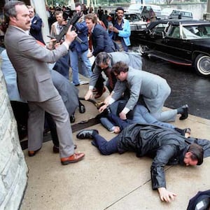 White House Press Secretary James Brady and District of Columbia police officer Thomas Delahanty lie wounded on the ground after John Hinckley Jr. fired six shots at President Ronald Reagan