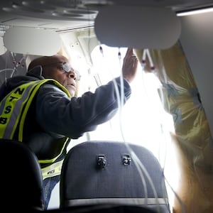 National Transportation Safety Board Investigator-in-Charge John Lovell examines the fuselage plug area of Alaska Airlines Flight 1282 Boeing 737-9 MAX on January 7, 2024 in Portland, Oregon