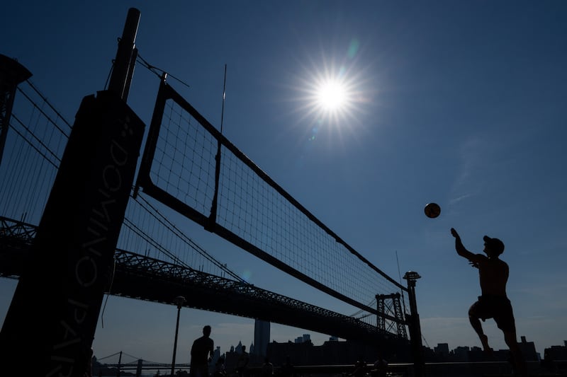 People play beach volleyball in Domino Park in Brooklyn, New York, as a heat wave hits the northeast US on June 18, 2024.