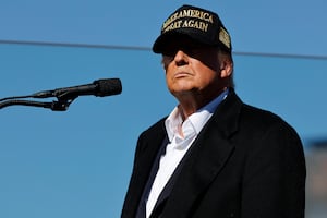 Trump in a black-and-gold MAGA hat.