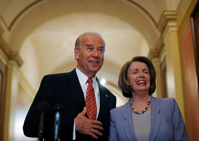 Joe Biden and Nancy Pelosi laugh together in old photo.