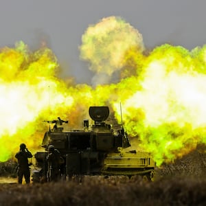 An IDF Artillery solider covers his ears as a shell is fired towards Gaza on October 11, 2023 near Netivot, Israel