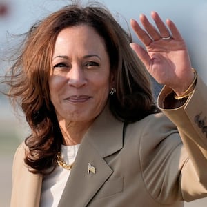 Kamala Harris waves to the crowd from the tarmac.