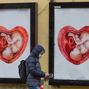 Two billboards with images of a fetus inside a heart shaped womb.