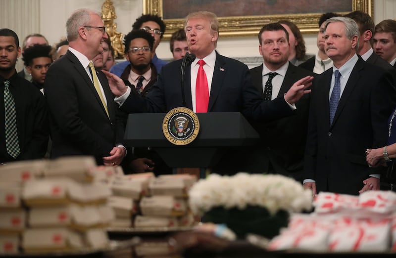 Trump speaks behind piles of fast food.