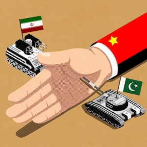 An illustration of a hand attached to an arm in a red suit with a yellow star pin keeps two tanks with the Pakistani and Iranian flags separated 