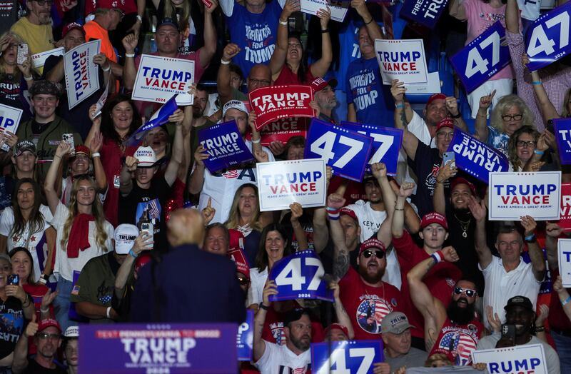 Donald Trump, back turned, turns to the audience at a rally