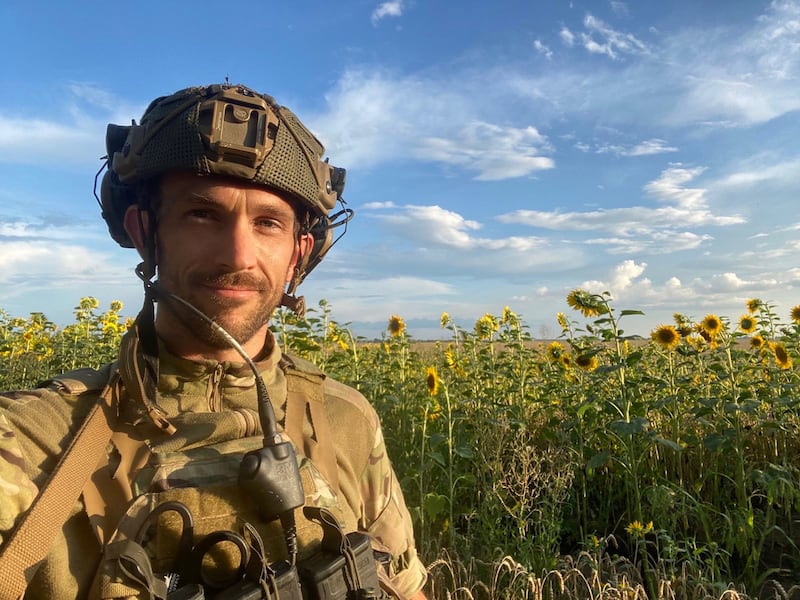 A U.S. veteran stands in a field of sunflowers in Ukraine during the Russia-Ukraine war