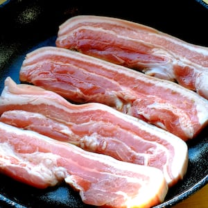 A panful of uncooked bacon.