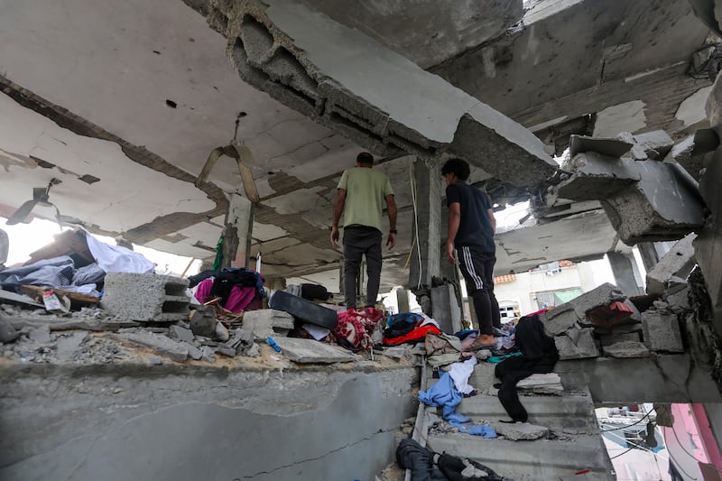 People search through buildings that were destroyed during Israeli air raids in the southern Gaza Strip in Khan Yunis, Gaza. 