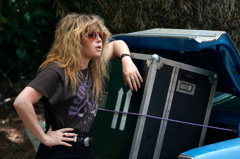 Natasha Lyonne leans against boxes in a still from ‘Poker Face’