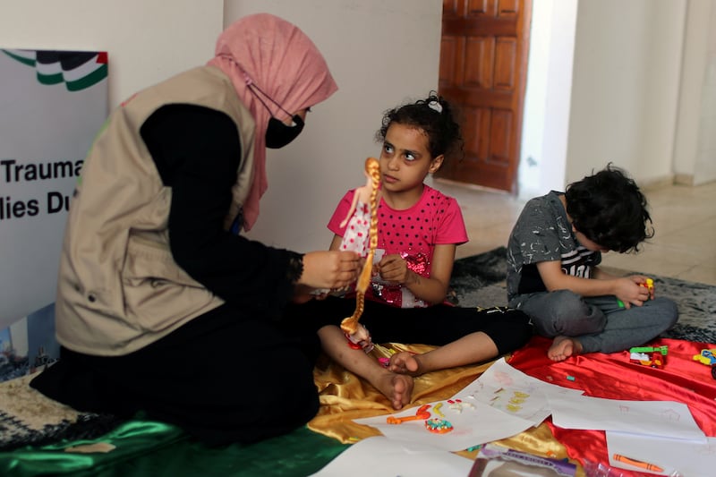 A psychologist plays with Palestinian girl Suzy Eshkuntana.