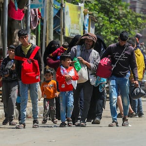 Gazans evacuate Rafah, carrying their belongings with their heads hung.