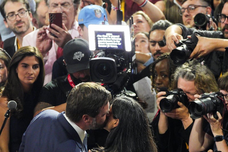 Republican vice presidential nominee J.D. Vance kisses his wife Usha Chilukuri Vance in front of cameras