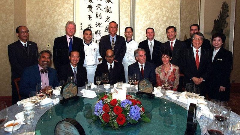 A photograph shows a group of people posing behind a dinner table that includes Goh Chok, Bill Clinton, Ghislaine Maxwell, and Jeffrey Epstein 