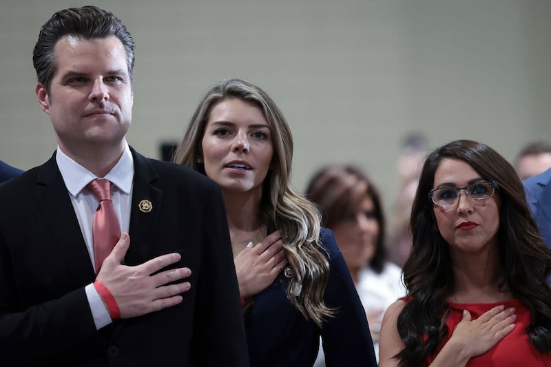 Rep. Matt Gaetz, left, Ginger Gaetz, center, and Rep. Lauren Boebert place their hands over their hearts as the Pledge of Allegiance is read during an introduction for Republican presidential candidate and former President Donald Trump at a Get Out the Vote rally in Richmond, Virginia.