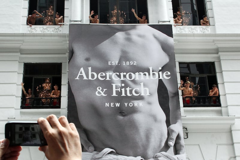 A man uses his mobile phone to take photographs of topless male models waving to a crowd of onlookers from the soon to open Abercrombie & Fitch flagship clothing store in Hong Kong on August 5, 2012. The store is due to be opened for trading on August 11.    AFP PHOTO / LAURENT FIEVET        (Photo credit should read LAURENT FIEVET/AFP/GettyImages)