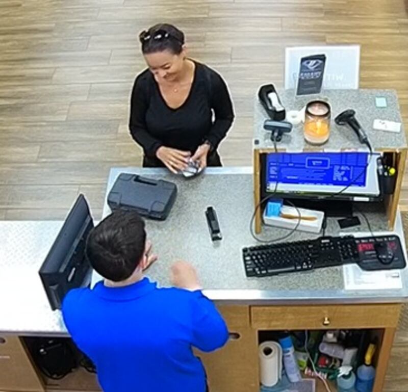 Mica Miller, dressed in all black, buys a handgun from a pawn shop.