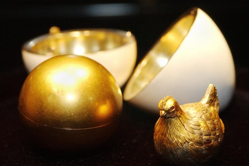 image of white egg, golden center with gold chick