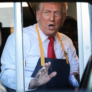 Donald Trump is seen speaking with supporters through the window of a McDonald's drive-thru.