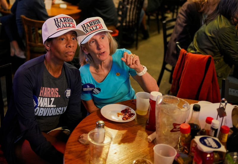 People wearing "Harris Walz '24" hats react to early election results during a 2024 U.S. Presidential Election Night Watch Party, at Manuel's Tavern, in Atlanta, Georgia, U.S., November 5, 2024. REUTERS/Cheney Orr