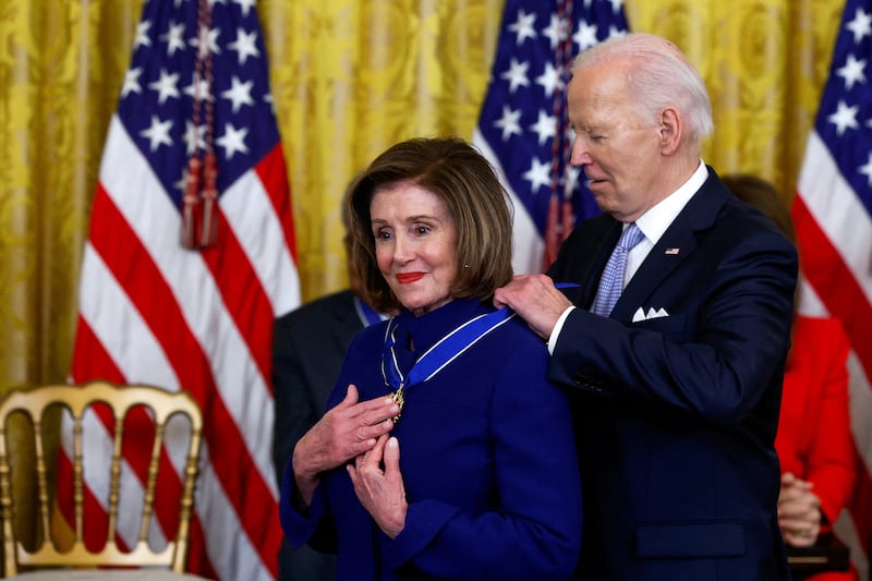 President Joe Biden puts the Presidential Medal of Freedom around the neck of former House Speaker Nancy Pelosi, who holds her hands over the medalion, during a ceremony at the White House in 2024.