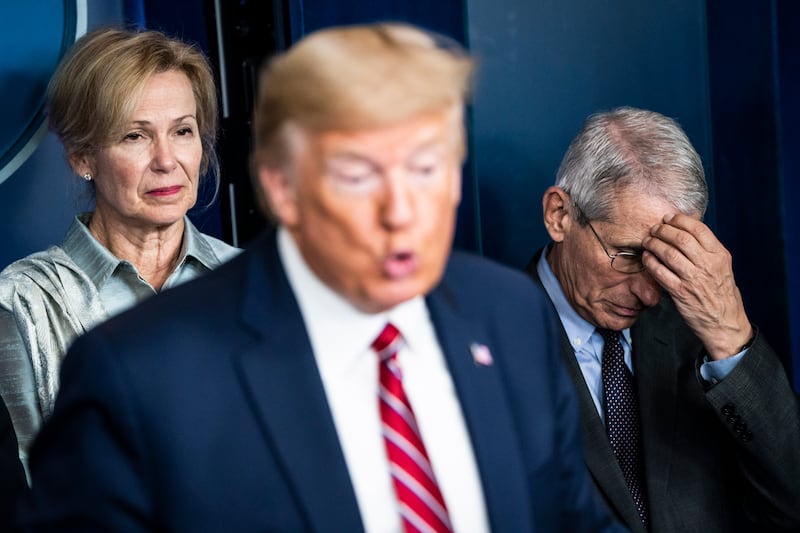 Anthony Fauci listens to Donald Trump speaking.